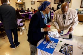 Christina Davis-McCoy and former Hoke County Sheriff Jim Davis, right, grab some campaign literature at a meeting with Sandhills North Carolina faith leaders in Lumberton, N.C., on Sept. 7.