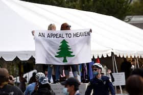 Supporters of President Donald Trump carry an “Appeal To Heaven” flag as they gather at Independence Mall before an ABC News town hall, Sept. 15, 2020, in Philadelphia.